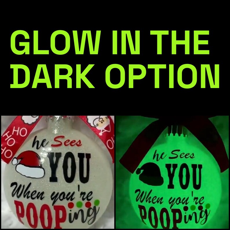 May include: A Christmas ornament with the text "he Sees YOU When you're Pooping." The ornament has a Santa hat graphic and a red ribbon. The image also shows the ornament glowing green in the dark, with the text "GLOW IN THE DARK OPTION."