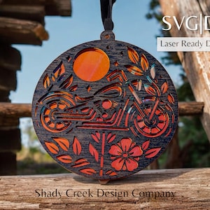 May include: A laser-cut wooden ornament featuring a motorcycle with a floral design. The ornament is painted in shades of red, orange, and black.