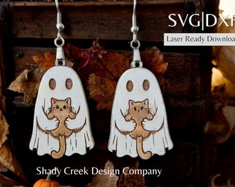 May include: A pair of wooden earrings featuring a white ghost holding a brown and white cat. The earrings are laser cut and ready to be assembled.  SVG|DXF Laser Ready Download. Shady Creek Design Company.