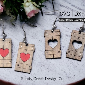 May include: A set of four wooden earrings with a heart cutout design. Two earrings feature a red heart painted on the front, while the other two have a heart cutout. The earrings are laser cut and ready to download as SVG and DXF files.  Shady Creek Design Co.