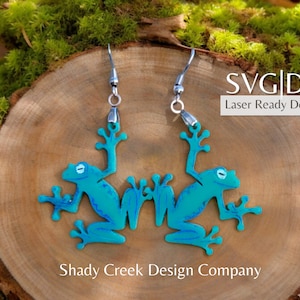 May include: A pair of turquoise frog earrings with silver hooks. The earrings are laser cut and ready to download as SVG and DXF files. Shady Creek Design Company.