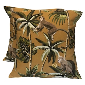 May include: Two mustard yellow throw pillows with a tropical print featuring monkeys and palm trees.