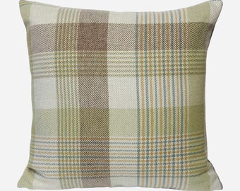 May include: A square throw pillow with a green, brown, and beige plaid pattern.