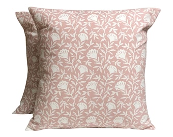 May include: Two pink pillow covers with a white floral pattern. The pattern features small white flowers and leaves on a light pink background.