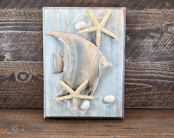 Cuadro decorativo de madera con forma de pez ángel náutico y estrella de mar con conchas marinas.