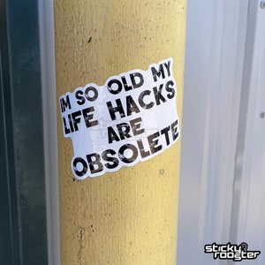 May include: A white sticker with black text on a yellow pole. The text reads "I'm so old my life hacks are obsolete."