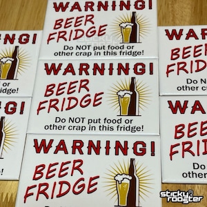 May include: Three white square warning signs with red text that reads "WARNING! BEER FRIDGE Do NOT put food or other crap in this fridge!"  Each sign features a cartoon image of a beer bottle and glass of beer.