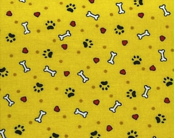 Empreintes de pattes noires, os blancs et coeurs rouges sur fond jaune.  Vendu par demi-mètre.