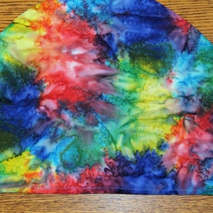 May include: A colorful tie-dye beanie hat with a blue, green, red, yellow, and purple pattern.