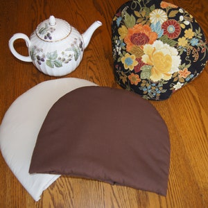 May include: Three chair cushions, one with a floral pattern, one brown, and one white.