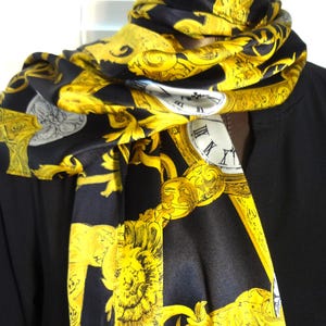 May include: Black silk scarf with a gold and white print of ornate clocks and floral designs.