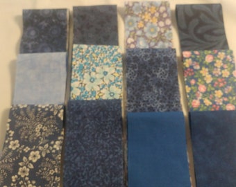 May include: A collection of 12 fabric strips in various shades of blue, some with floral patterns, others with geometric designs. The fabric strips are arranged in a grid pattern.