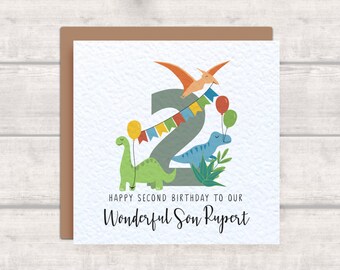 May include: A birthday card with a gray number two surrounded by dinosaurs, balloons, and a banner. The text reads "Happy Second Birthday to our Wonderful Son Rupert".