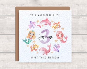 Puede incluir: Una tarjeta de cumpleaños con una ilustración de acuarela de sirenas, un delfín y una ballena. La tarjeta dice "To a wonderful niece Jasmine Happy Third Birthday".