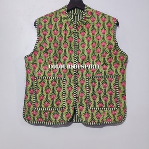 May include: A green quilted vest with a pink floral print and white stripes. The vest has a mandarin collar, a button closure, and two pockets. The text "COLOURSOFSPIRIT" is printed on the front of the vest.