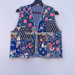 Könnte beinhalten: Eine blaue gesteppte Weste mit Patchwork-Muster, das florale und geometrische Muster in den Farben Rosa, Grün, Gelb und Weiß zeigt. Die Weste hat einen V-Ausschnitt und ein gestreiftes Futter.