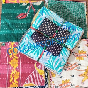 Puede incluir: Una pila de cuadrados de tela coloridos con una variedad de patrones, incluyendo diseños florales, geométricos y paisley. Los cuadrados de tela están cosidos juntos y tienen un aspecto rústico y hecho a mano. El texto "COLOURS OF SPIRIT" es visible en la tela.