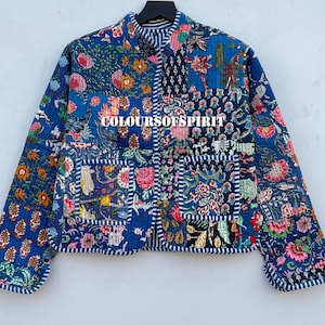 Könnte beinhalten: Gesteppte Jacke mit Patchwork-Design mit Blumen- und Pflanzenmustern in Blau, Rosa und Grün. Die Jacke hat einen Stehkragen und den Text "COLOURSOFSPIRIT".