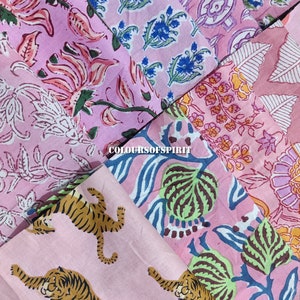May include: A collection of pink fabric squares with different floral and animal prints. The prints include tigers, leaves, and flowers. The fabric is a light pink color with blue, green, and brown accents.