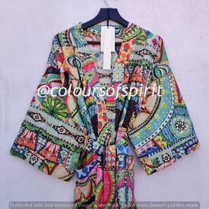Puede incluir: Una bata de kimono colorida y estampada con cuello en V y mangas largas. La bata tiene una variedad de colores y patrones, incluyendo rosa, azul, verde, amarillo y rojo. La bata se ata a la cintura con un cinturón a juego.