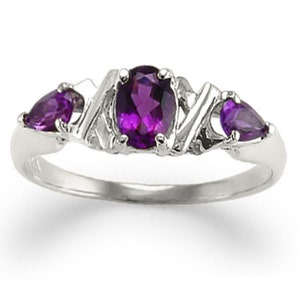 May include: A silver ring with three amethyst gemstones. The center stone is oval shaped and the two side stones are pear shaped.