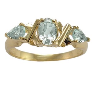May include: A gold ring featuring three aquamarine gemstones. The center stone is oval-shaped, flanked by two pear-shaped stones. The ring has a classic design with a polished finish.