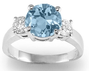 May include: A silver ring with a large oval aquamarine gemstone and two smaller round diamonds on either side.
