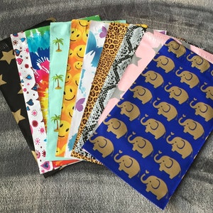 May include: A collection of 12 colorful patterned mailing envelopes with a variety of designs, including stars, hearts, palm trees, smiley faces, butterflies, and elephants. The envelopes are all made of a durable, lightweight material and are perfect for sending letters, cards, and small gifts.