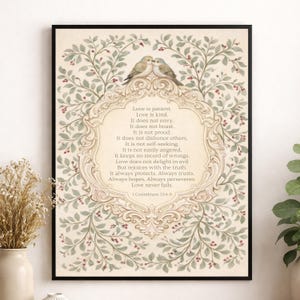 May include: Framed art print featuring a decorative border of green leaves and red berries. Two birds perch atop a central ornate frame containing the text of 1 Corinthians 13:4-8, a passage about love.