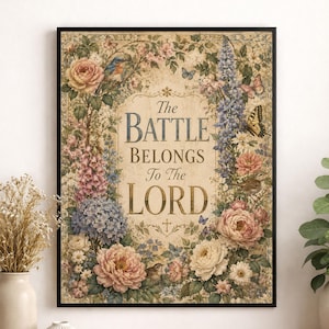 以下が含まれることがあります： セリフフォントで「The BATTLE BELONGS To The LORD」というテキストが書かれた額装されたウォールアートプリント。テキストは、ピンクと白のバラ、青いアジサイ、背の高い紫の花、蝶、鳥の精巧な植物イラストで囲まれています。