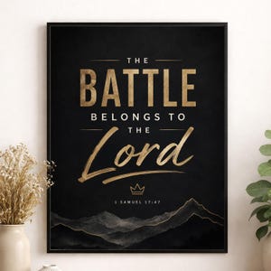 以下が含まれることがあります： 黒い背景に金色の文字で「THE BATTLE BELONGS TO THE Lord」と書かれた長方形のウォールアートプリント。小さな金色の王冠のアイコンと「1 SAMUEL 17:47」という文字の下に、金と黒で描かれた山脈のグラフィックが配置されています。