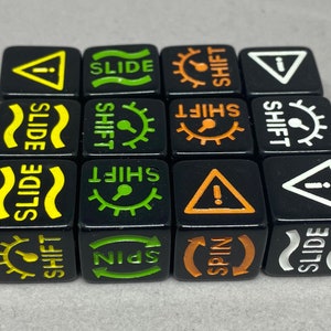 May include: Twelve black dice with various symbols and text, including "SLIDE", "SHIFT", "SPIN", and exclamation points. The dice are arranged in a 4x3 grid.