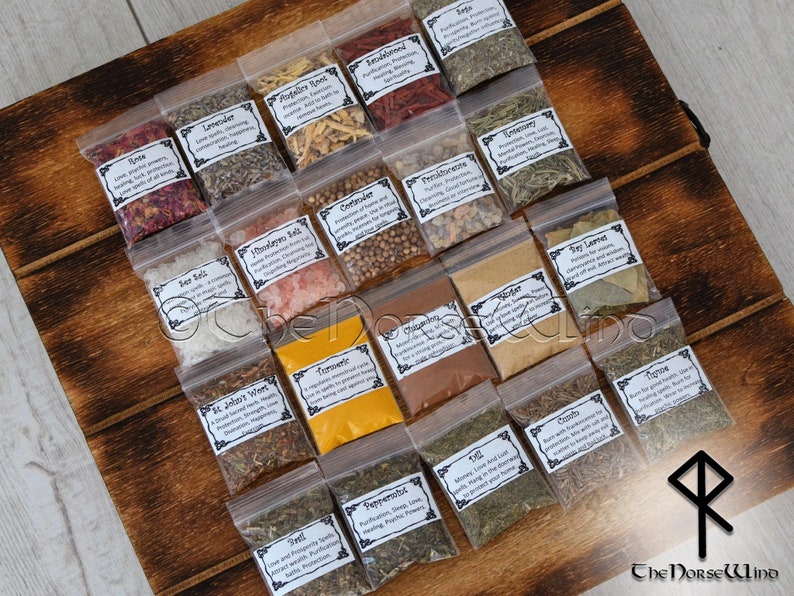May include: A wooden box filled with small clear plastic bags containing various dried herbs and spices. Each bag has a label with the name of the herb or spice and a description of its uses. The box is labeled "The Norse Wind".