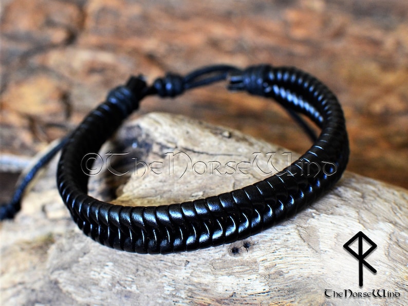 May include: Black leather bracelet with a braided design. The bracelet has a simple knot closure.