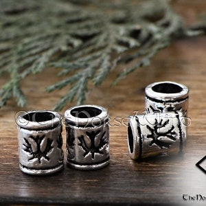 May include: Four silver metal beads with a decorative design. The beads are about 1 inch in diameter and have a smooth, polished finish.