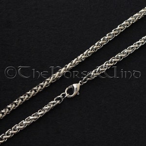 May include: A silver chain necklace with a lobster clasp. The chain is made of a braided design.
