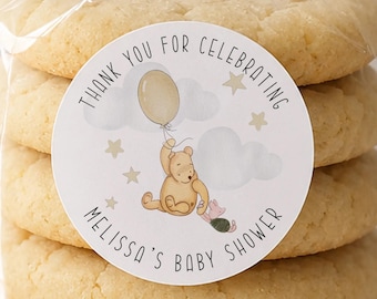 May include: A stack of five round sugar cookies in a clear plastic bag with a circular sticker. The sticker features a yellow bear holding a balloon, a small pink pig, clouds, stars, and the text Thank You For Celebrating Melissa's Baby Shower.
