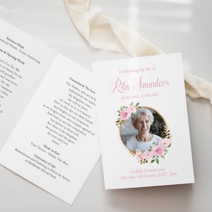 May include: A white memorial service booklet with a pink floral design and a photo of a woman. The program includes the text "Celebrating the life of Rita Saunders 24.05.1942 - 11.09.2023" and "Getting Cremation Thursday 5th October 2023 - 3pm".