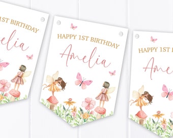 Könnte beinhalten: Drei weiße Wimpelbanner mit rosa und goldenem Text, der "Happy 1st Birthday Amelia" lautet. Jeder Banner zeigt eine Aquarell-Illustration von Feen mit rosa Flügeln und Blumen.