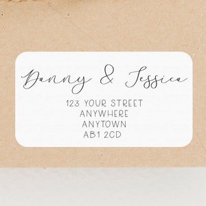 Peut inclure: Étiquette d'adresse de retour blanche avec du texte noir. Le texte indique "Danny & Jessica", "123 Your Street", "Anywhere", "Anytown", "AB1 2CD".