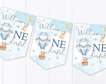 May include: Three pennant flags featuring a watercolor design of a light blue and white hot air balloon, a brown teddy bear in the basket holding a telescope, and a yellow star. The text reads William is ONEderful in blue and black script.