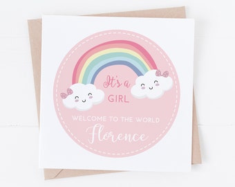 May include: A pink card with a rainbow and two clouds with faces. The text on the card reads "It's a girl" and "Welcome to the world Florence".
