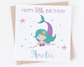 Puede incluir: Tarjeta de cumpleaños con una ilustración de sirena. La tarjeta tiene el texto "HAPPY 5th BIRTHDAY" en morado, con el nombre "Amelia" en turquesa y rosa. La sirena tiene pelo turquesa, una cola morada y está rodeada de estrellas y estrellas de mar.