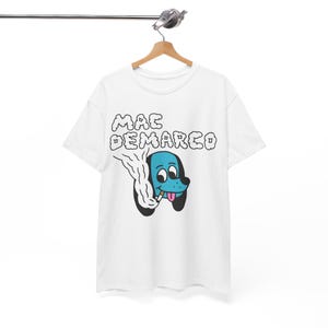 May include: White t-shirt with a blue cartoon dog smoking a cigarette and the text "MAC DEMARCO" in black.