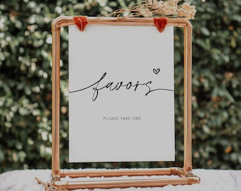 May include: A copper pipe frame holds a white sign with the text "favors" and a small heart symbol. The sign also says "Please take one".