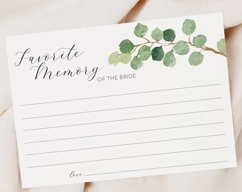 May include: White card with a green watercolor eucalyptus branch design. The card has the text "Favorite Memory of the Bride" and lines for writing.