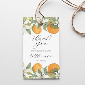 May include: White thank you tag with orange blossoms and oranges. The text reads "Thank you for showering our little cutie with love."