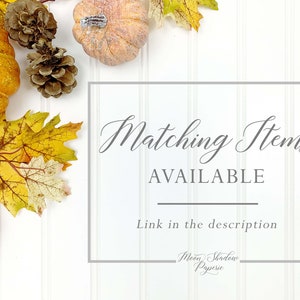 K&ouml;nnte beinhalten: Ein wei&szlig;er Hintergrund mit Herbstdekorationen, darunter K&uuml;rbisse, Tannenzapfen und Herbstbl&auml;tter. Der Text "Matching Items AVAILABLE" befindet sich in einem grauen Kasten mit dem Text "Link in the description" darunter. Der Text "Moon Shadow Paperie" befindet sich am unteren Rand des Bildes.
