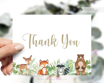 May include: A thank you card with a woodland theme. The card features a deer, fox, raccoon, and bear surrounded by green leaves. The text "Thank You" is written in gold lettering.