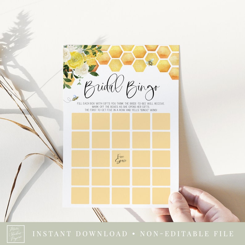 Puede incluir: Una tarjeta de juego de despedida de soltera imprimible con un dise&ntilde;o floral amarillo y blanco y un patr&oacute;n de panal. La tarjeta dice "Bridal Bingo" e incluye instrucciones para jugar el juego.